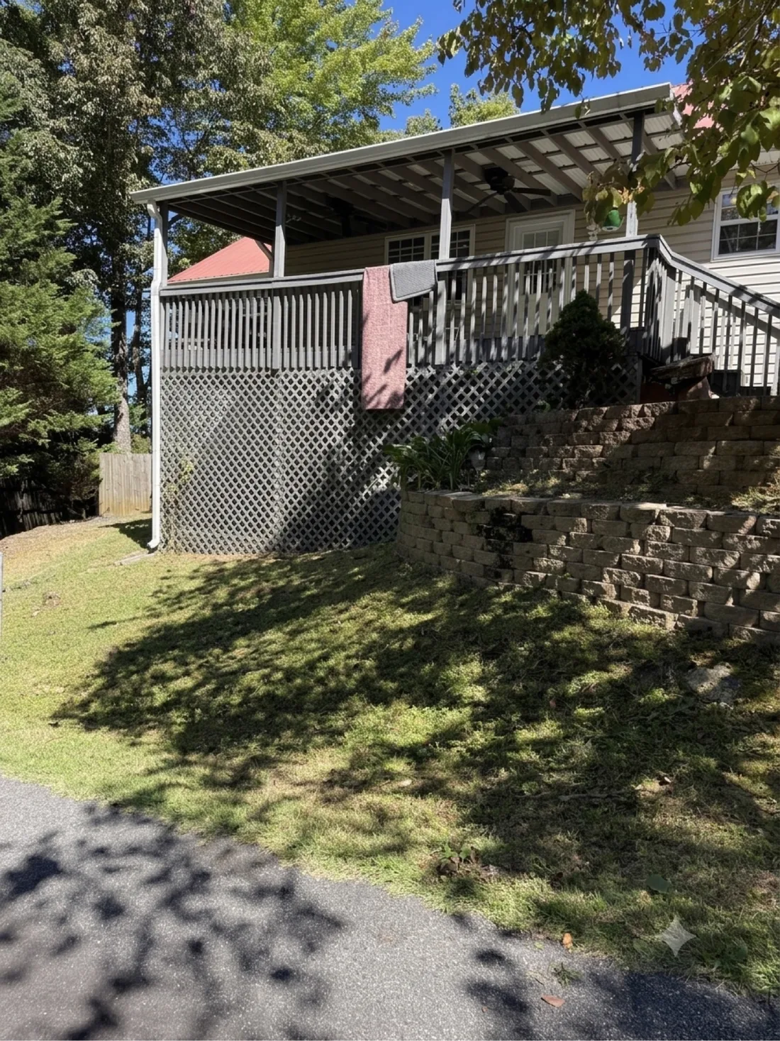 Cleared lawn, retaining wall, and porch after underbrush removal