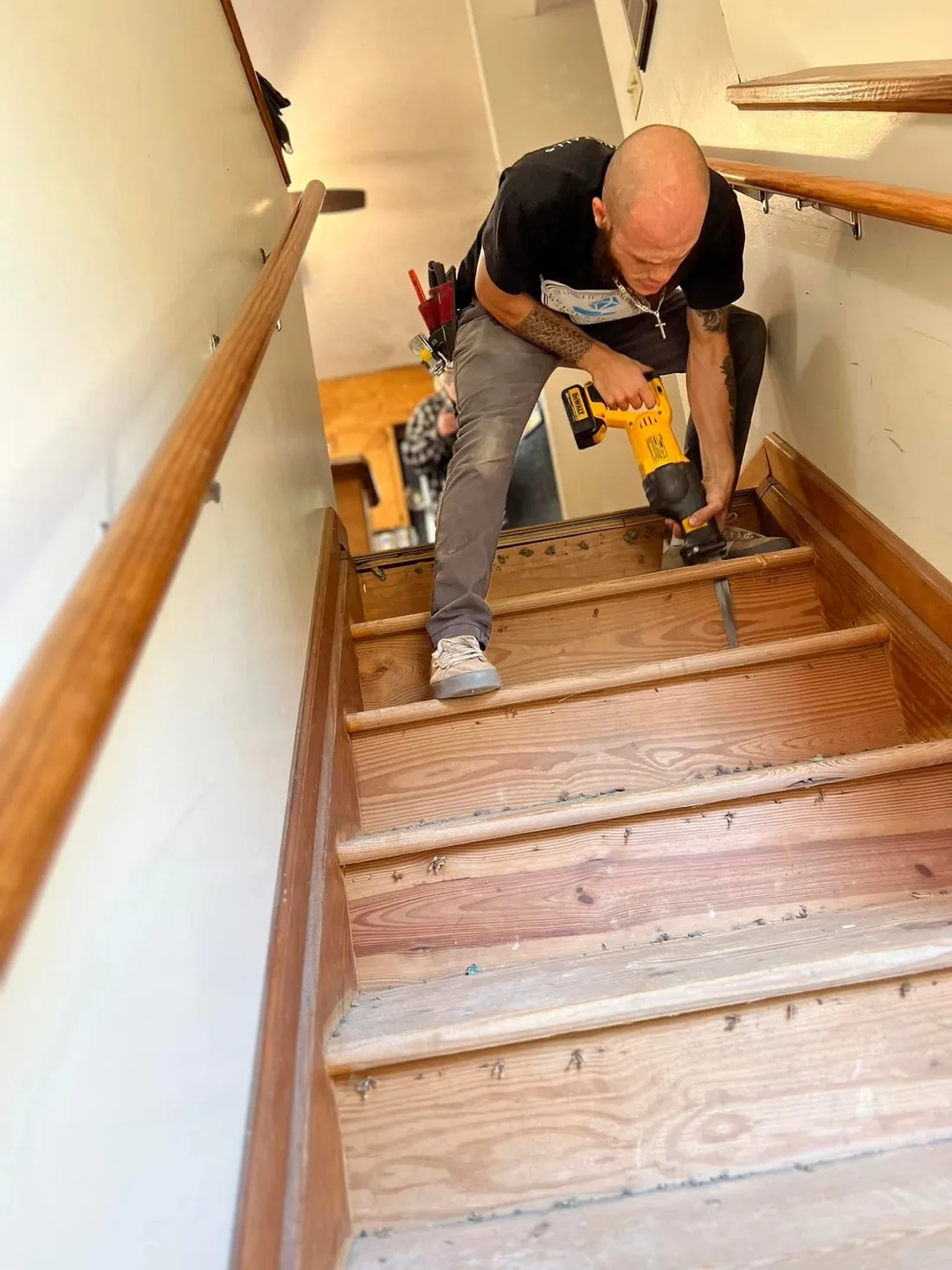 Craftsman fitting wood flooring on an interior staircase
